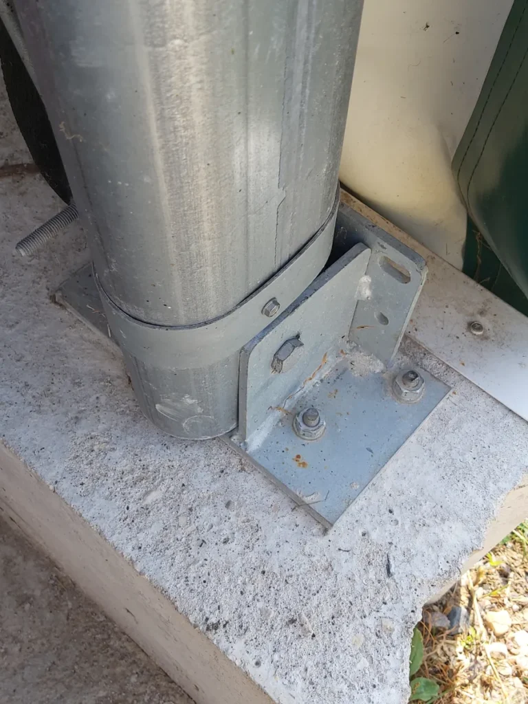Galvaniserad stålstolpe med korsbeslag förankrad i betong